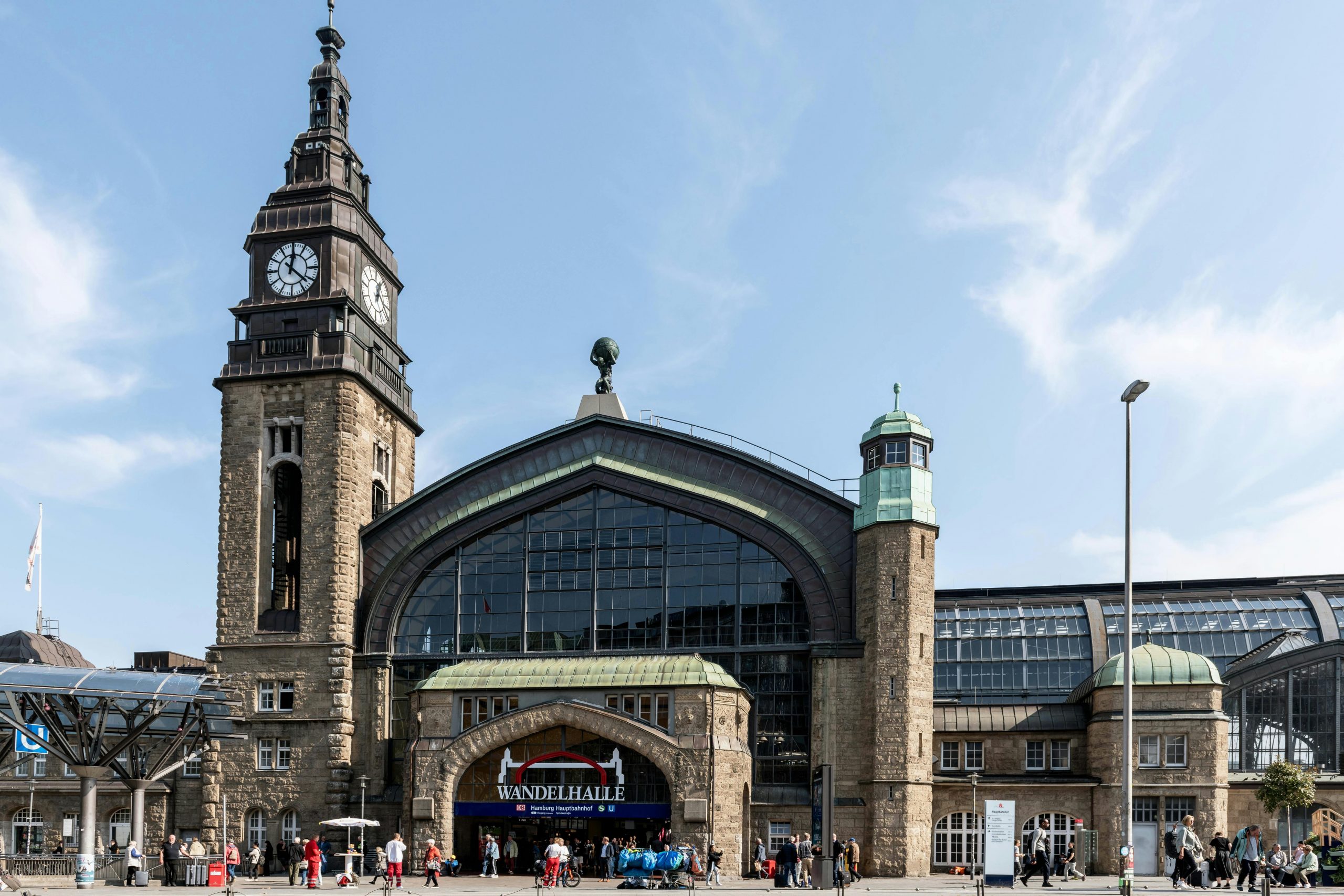 Explore the architectural beauty of Hamburg Hauptbahnhof with its iconic clock tower and bustling entrance.