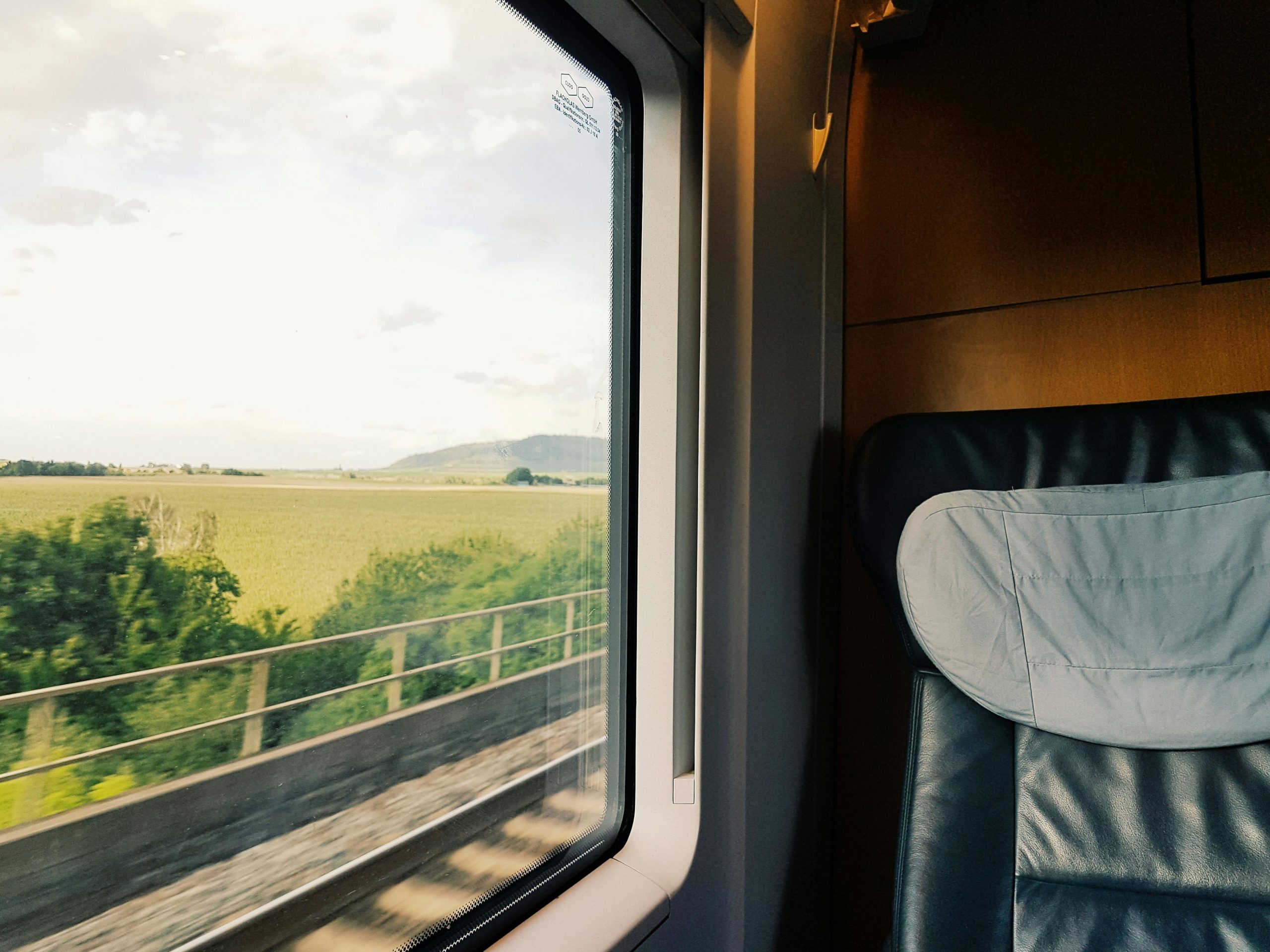 Captivating view of the countryside from a train window during daylight.